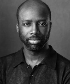 A black and white headshot of actor Jo Servi