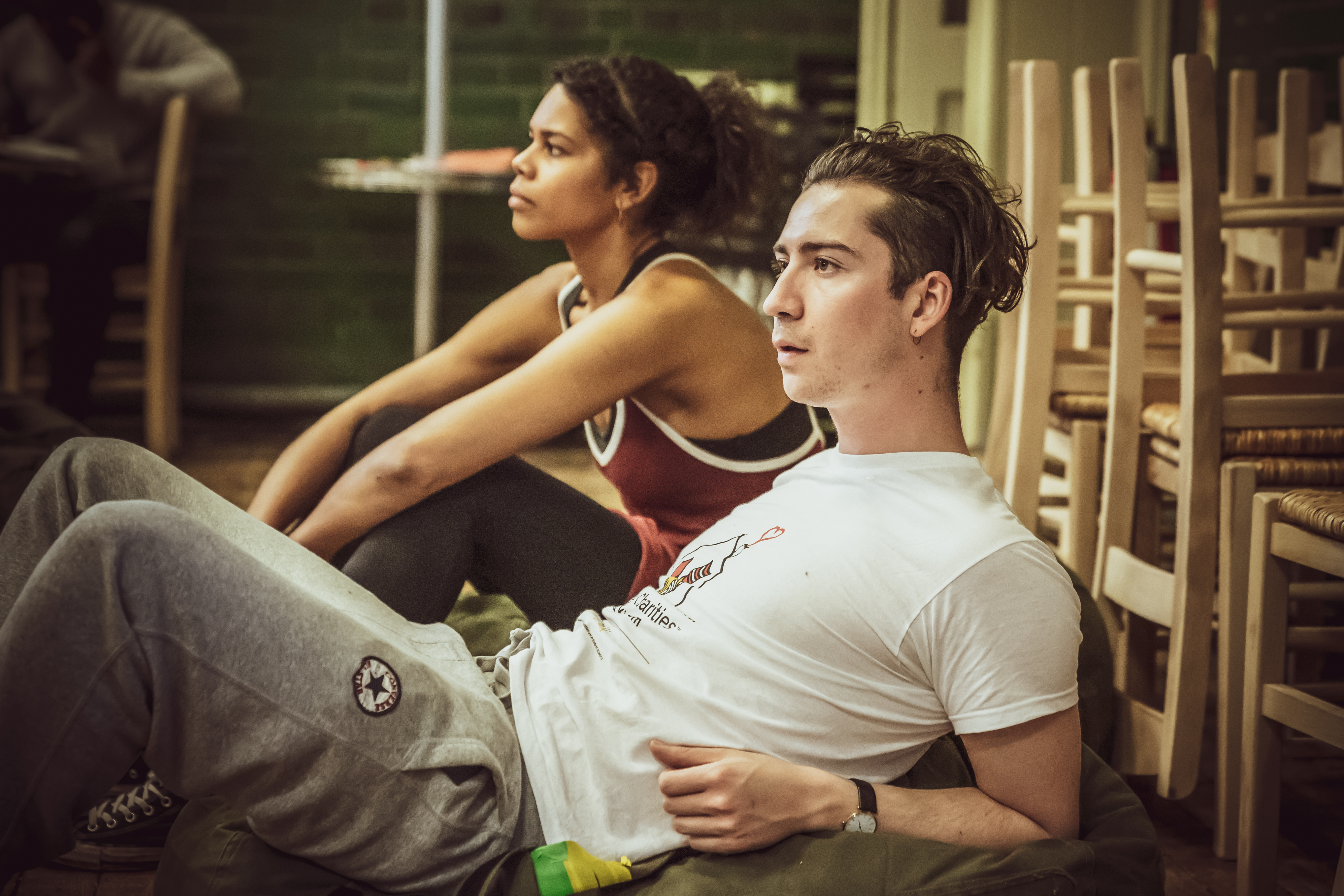 A male and female cast member laying down relaxed