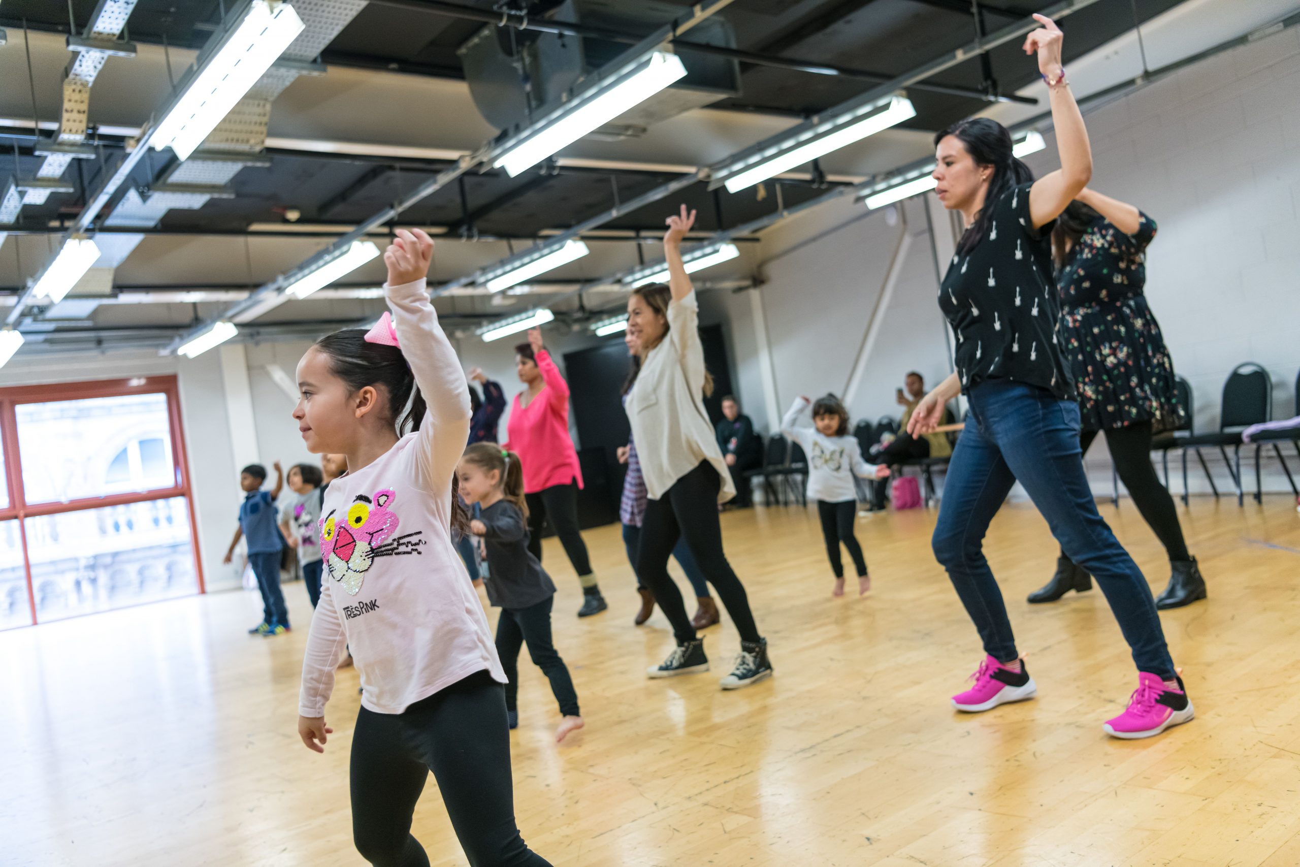 Children and their adults participating in a movement workshop.