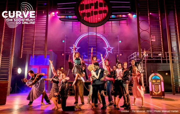 Production image from Grease - The Musical showing the company posing together at the Burger Palace.