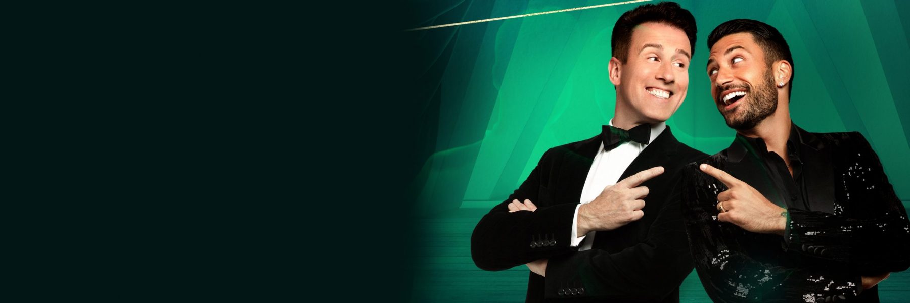 Promotional artwork for Anton Du Beke and Giovanni Pernice in Him & Me. Anton and Giovanni smile and point at one another in black suits, against an illustrated background of blue/green theatre curtains.
    
