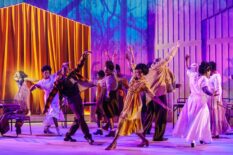 The cast of The Color Purple dance joyously with out-stretched arms on stage